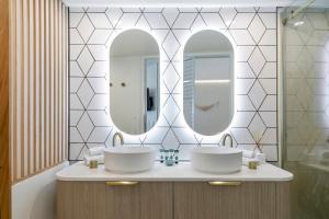 a bathroom with two sinks and two mirrors at Noosa Blue Resort in Noosa Heads