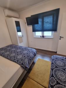 ein kleines Schlafzimmer mit einem Bett und einem Fenster in der Unterkunft Apartman Migliore in Sesvete