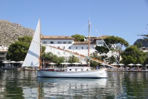 un velero en el agua frente a un edificio en Hotel Illa d'Or & Club Apts 4* Sup en Port de Pollensa