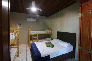 a bedroom with a bed and two bunk beds at Pousada Praia Mongaguá em Frente ao Mar com Piscina e Churrasqueira in Mongaguá