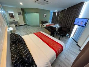 ein Hotelzimmer mit einem Bett und einem Wohnzimmer in der Unterkunft N&L HOTEL KUALA TERENGGANU in Kuala Terengganu