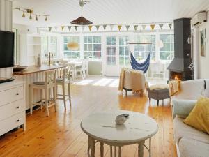 Holiday home GRISSLEHAMN XIII في جريسليهامن: مطبخ وغرفة معيشة مع طاولة وغرفة معيشة