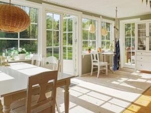 a kitchen with a table and chairs and windows at 5 person holiday home in GRISSLEHAMN-By Traum in Grisslehamn +23 photos