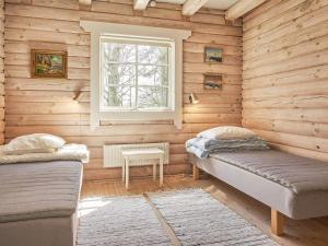 a room with two beds in a wooden wall at Holiday home Rønne XXII in Rønne