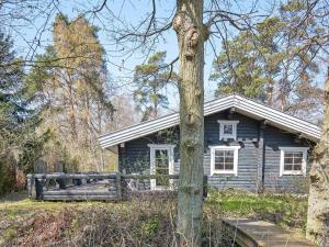 a blue house in the middle of a forest at Holiday home Rønne XXII in Rønne