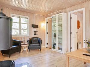 a living room with a chair and a table at Holiday home Aakirkeby LXIII in Vester Sømarken