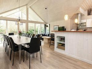 a dining room and living room with a table and chairs at Holiday home Væggerløse LXXXIX in Marielyst