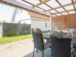 a patio with chairs and a table and a fence at 4 person holiday home in Sydals in Østerby
