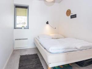 białe łóżko w pokoju z oknem w obiekcie Holiday home Aabenraa LXXIV w mieście Aabenraa