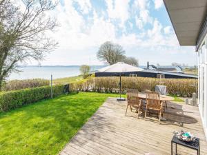 a patio with a table and chairs and a lawn at Holiday home Aabenraa LXXIV in Aabenraa