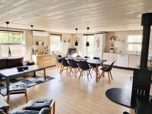 uma cozinha e sala de estar com mesa e cadeiras em Holiday home Rømø XV em Bolilmark