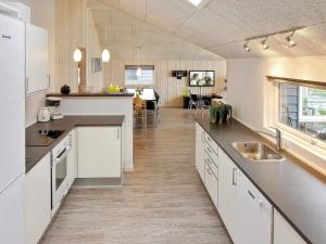 a large kitchen with white cabinets and a dining room at Holiday home Sydals LXXXVI in Sønderby
