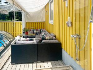 un patio con un sofá en una terraza en Holiday home FÄRENTUNA IV, 