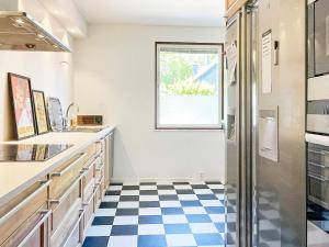 uma cozinha com um piso xadrez azul e branco em Holiday home Västervik III em Västervik