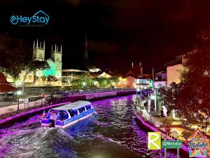 a boat traveling down a river at night at Wayfarer Guest House Jonker Street Melaka By Heystay Management in Melaka