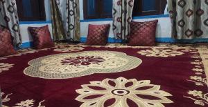 una habitación con una alfombra roja con una flor. en POP Maryam Homestay en Gāndarbal