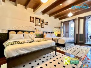 a bedroom with two beds and a balcony at Wayfarer Guest House Jonker Street Melaka By Heystay Management in Melaka