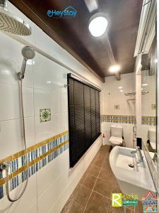 a bathroom with a shower and a sink and a toilet at Wayfarer Guest House Jonker Street Melaka By Heystay Management in Melaka