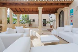 ein Wohnzimmer mit weißen Sofas und einem Tisch in der Unterkunft Hotel Illa d'Or & Club Apts 4* Sup in Port de Pollença