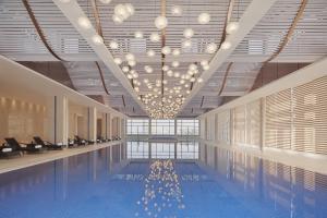 einen Pool mit Kronleuchtern in einem Gebäude in der Unterkunft The International Trade City, Yiwu - Marriott Executive Apartments in Yiwu