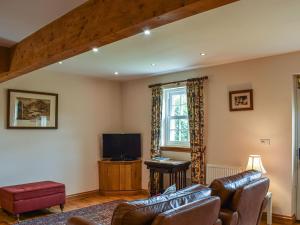 a living room with a couch and a tv at Frasers Cottage in Salen