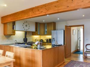 a kitchen with wooden cabinets and a refrigerator at Frasers Cottage in Salen