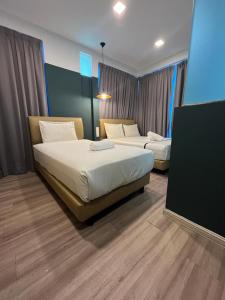 um quarto de hotel com duas camas e uma televisão em Smile Hotel Subang Airport em Shah Alam