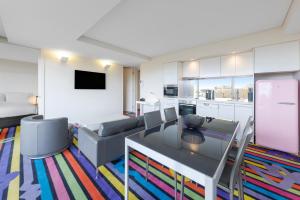 uma sala de estar com uma mesa e um sofá em Adge Hotel and Residences em Sydney