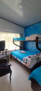 a bedroom with two bunk beds and a window at Villa Sarita Zona Rural de Melgar a 28 Minutos del Casco Urbano in Melgar