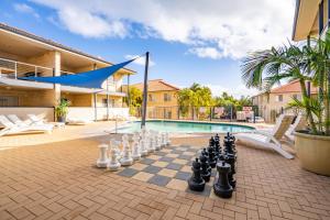 un tablero de ajedrez en un patio junto a una piscina en Kalbarri Edge Resort en Kalbarri