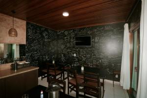 a restaurant with a chalkboard wall with a table and chairs at Pousada Praia Mongaguá em Frente ao Mar com Piscina e Churrasqueira in Mongaguá