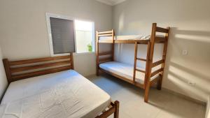 En eller flere senge i et værelse på Casa Peruibe com Piscina Mtk2 + 36 billeder