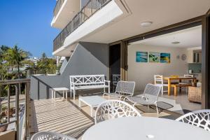 a balcony with white tables and chairs on a building at The Rocks Resort Unit 3C in Gold Coast