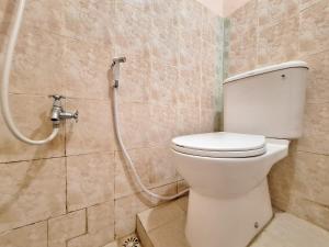 a bathroom with a toilet and a shower at RedDoorz Syariah near Pasar Raya Padang in Padang +13 photos