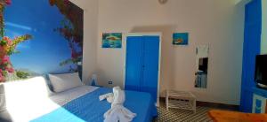 a bedroom with a blue bed and a blue door at Casetta Colorata in Bagheria