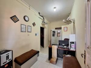a office with a desk and a computer on a wall at RedDoorz Syariah near Pasar Raya Padang in Padang