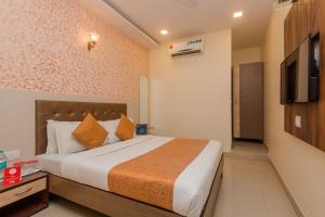 a bedroom with a bed and a flat screen tv at Hotel Golden Nest Near Chhatrapati Shivaji International Airport in Mumbai