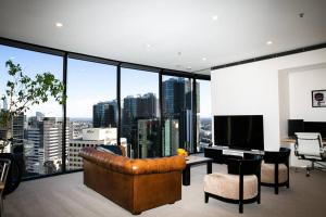 Sydney Sky high Self-Catering في سيدني: غرفة معيشة مع أريكة ومكتب مع تلفزيون