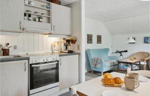 a kitchen with white cabinets and a table with food on it at 2 Bedroom Cozy Home In Stege in Stege
