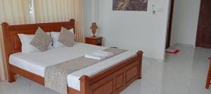 een slaapkamer met een bed met witte lakens en kussens bij Bivon Reach By Travel Corners in Uswetakeiyawa