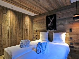 a bedroom with two beds with shoes on them at Appartement chic Méribel - skis aux pieds, cheminée & parking - FR-1-613-40 in Méribel