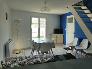 ein Zimmer mit einem Tisch, Stühlen und einer Treppe in der Unterkunft Maison La Tranche-sur-Mer, 3 pièces, 5 personnes - FR-1-194-267 in La Tranche-sur-Mer