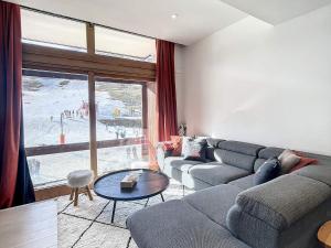 un soggiorno con un divano e un tavolo di Duplex spacieux au pied des pistes avec accès piscine - FR-1-267-255 a Villarembert