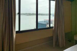 a room with a window with a view of the water at Hotel Laut Jaya Tanjung Pinang RedPartner in Tanjung Pinang