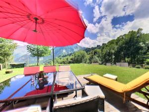 una barca con un ombrellone rosso accanto a una piscina di Chalet 3* · 8 pers · Grand confort · Terrasse · Parking privé - FR-1-267-266 a Villarembert