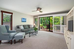 a living room with a couch and a tv at Waikomo Streams 203 in Koloa