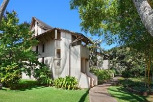 a white house with a garden and a driveway at Waikomo Streams 203 in Koloa