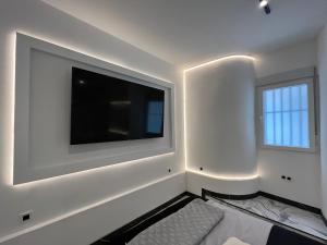 Biały pokój z dużym telewizorem na ścianie w obiekcie BS4 suite Luxury Madrid centro w Madrycie