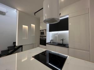kuchnia z białymi szafkami i czarnym blatem w obiekcie BS4 suite Luxury Madrid centro w Madrycie +10 zdjęć