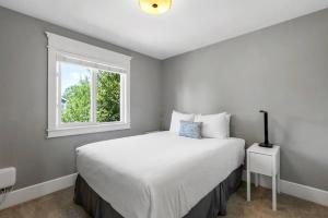 sypialnia z dużym białym łóżkiem i oknem w obiekcie Comfort and joy w mieście Prince George